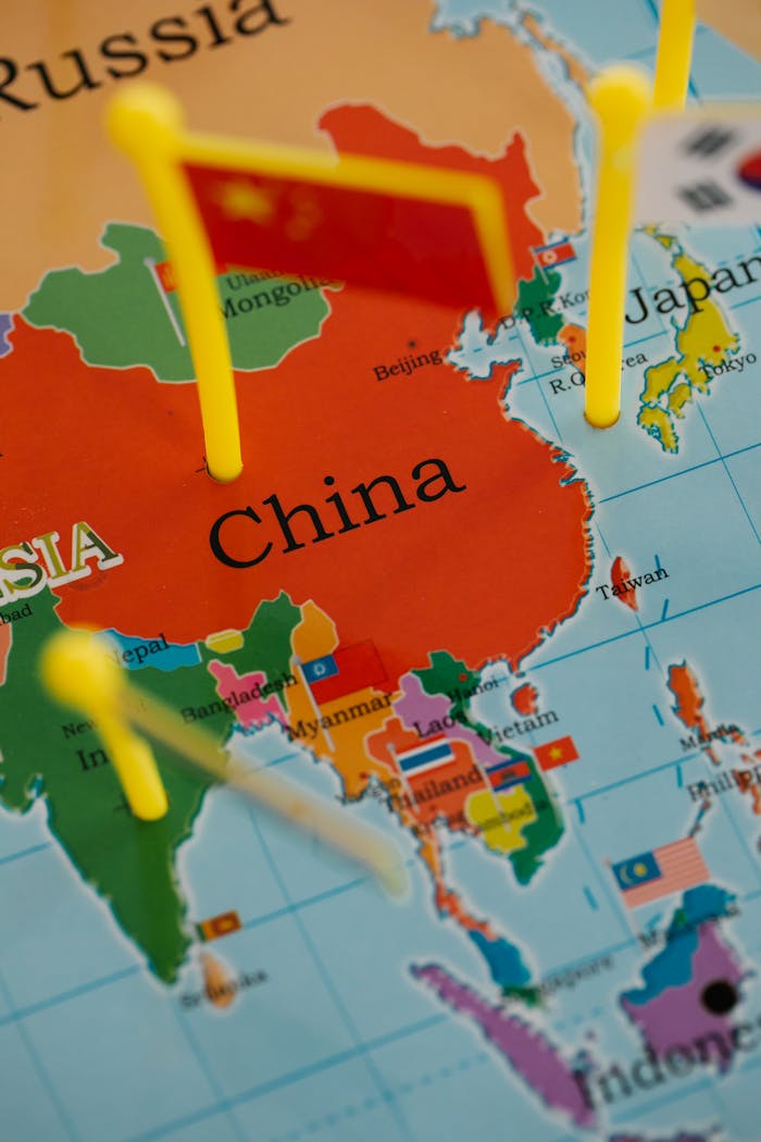 Close-up of a map highlighting China with colorful pins and flags in Asia.